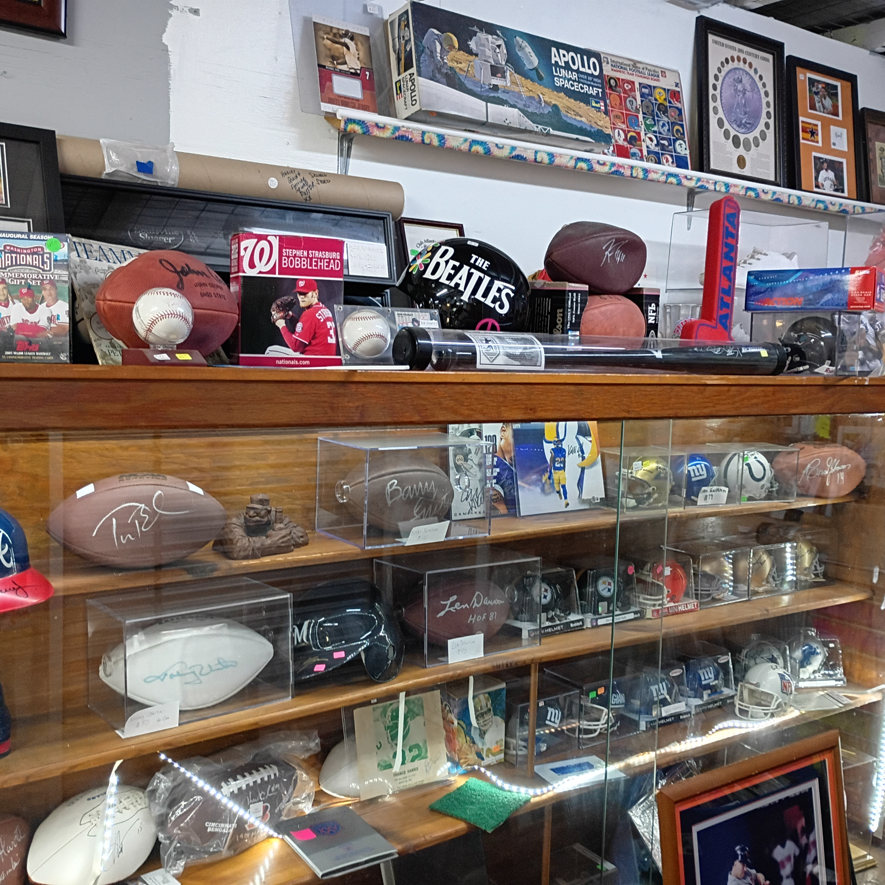 Display case with signed footballs, mini helmets, and framed memorabilia at Finn McCool's.